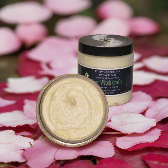 Jar of 'Curly Concoction' with a lid removed on a decorative background with flowers and lights.